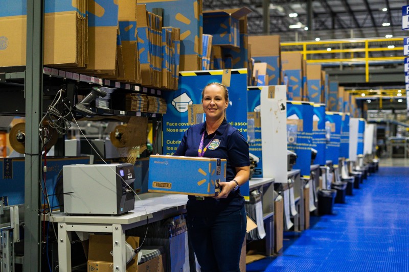 Supply Chain associate carrying a box