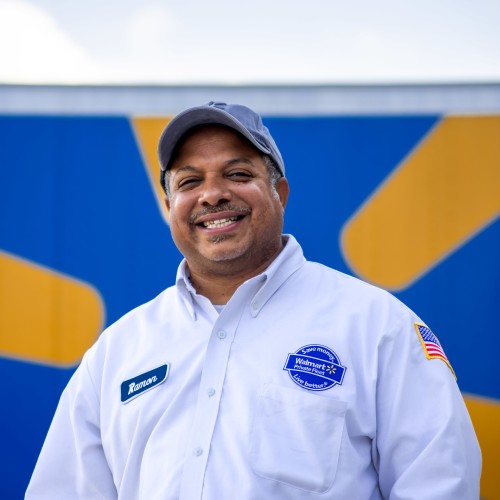 A driver smiling in front of a truck