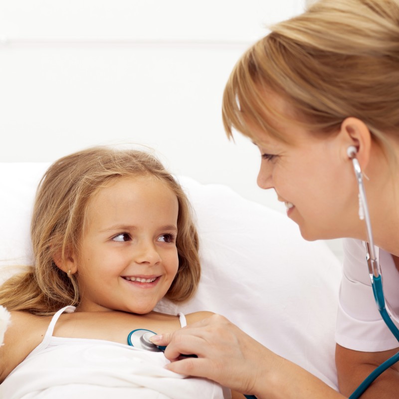 Nurse listening to a little girl's heart beat