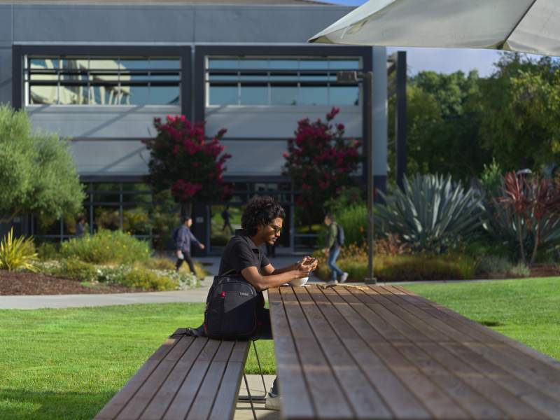 Global tech employee sitting at a picnic table