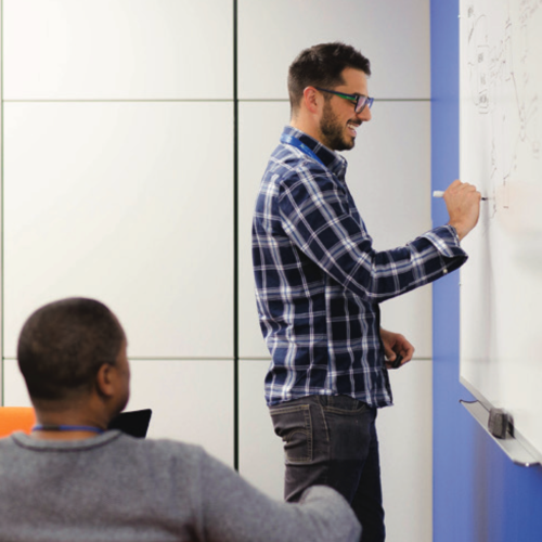 Walmart associate writing on a whiteboard. 